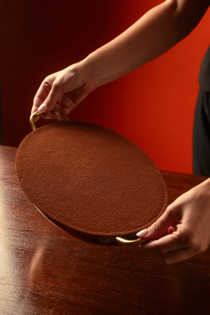 Whole cocoa-dusted tiramisu presented on a serving tray at Matto in St George’s Bay